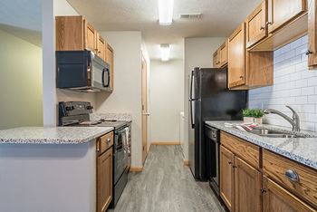 Interiors- kitchen with hardwood-style flooring and subway tile backsplash at williamsburg park apartments in lincoln ne